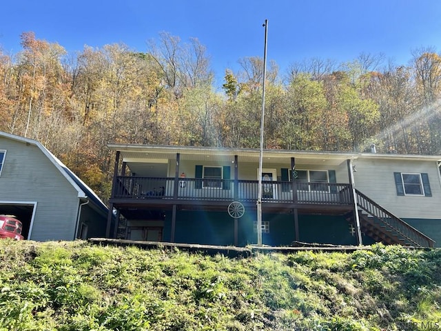 rear view of property featuring a wooden deck