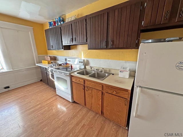 kitchen featuring white appliances, light hardwood / wood-style floors, and sink