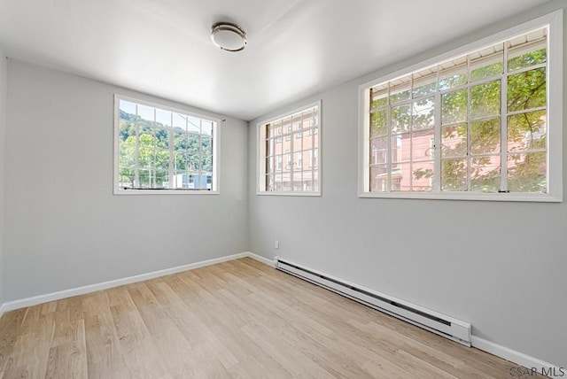 empty room featuring light hardwood / wood-style flooring and a baseboard heating unit