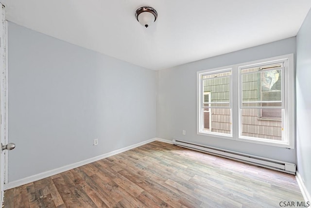 unfurnished room with a baseboard radiator and light wood-type flooring