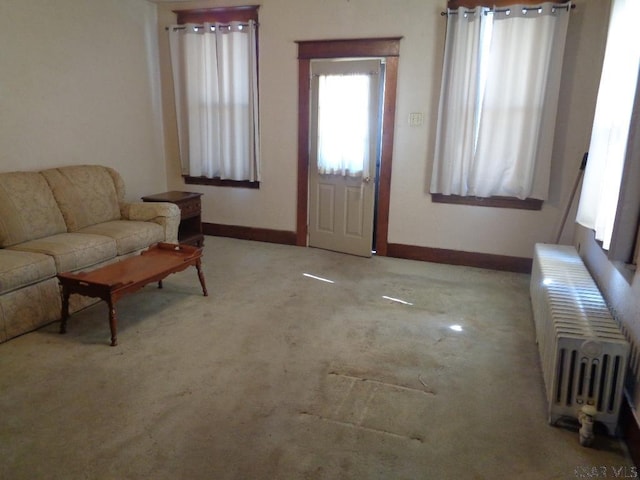 carpeted living area featuring baseboards and radiator