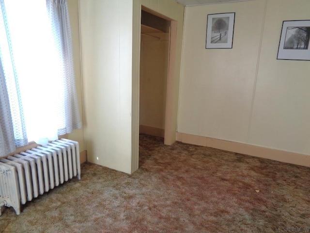 unfurnished bedroom featuring carpet flooring and radiator