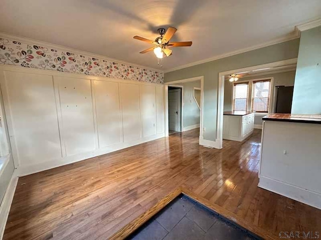 interior space with hardwood / wood-style flooring, ceiling fan, and ornamental molding