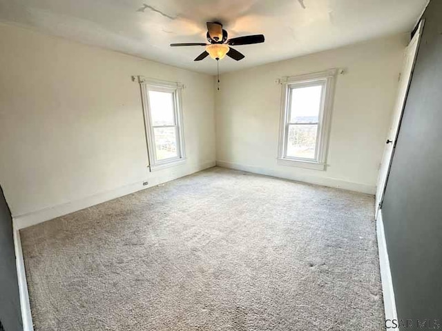 unfurnished room with a healthy amount of sunlight, light colored carpet, and ceiling fan