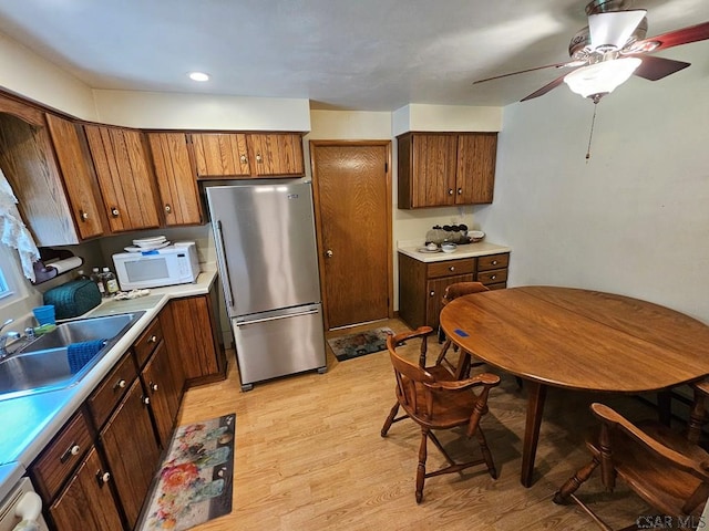 1827 Saylor School Rd, Boswell, PA 15531 - kitchen with freestanding refrigerator, white microwave, light wood-type flooring, a sink, and light countertops