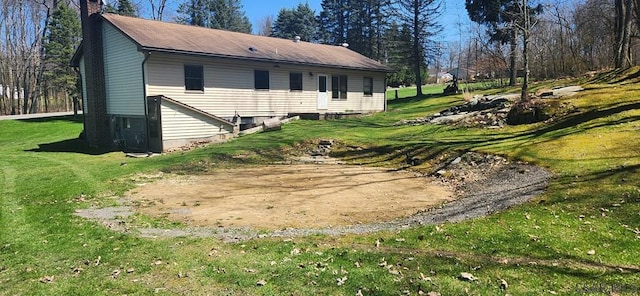 back of property with a lawn and a chimney
