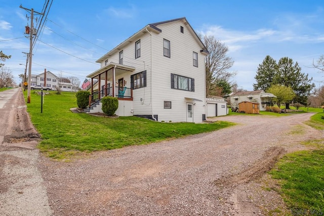 view of side of property featuring a yard, a garage, and driveway