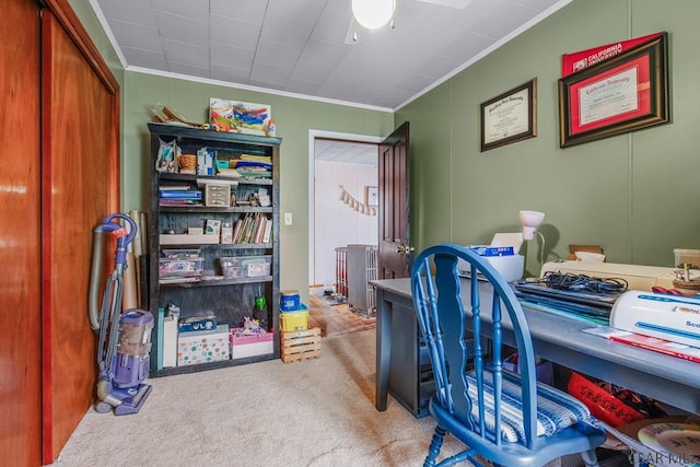 carpeted office space with a ceiling fan and ornamental molding