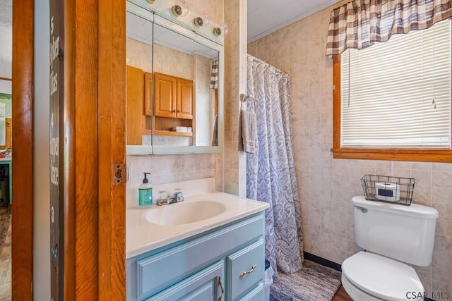 full bathroom featuring toilet, curtained shower, vanity, and tile walls