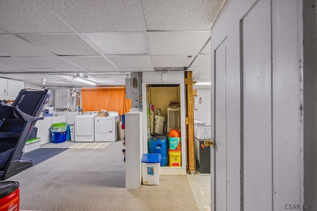 basement with carpet, washing machine and dryer, and a paneled ceiling