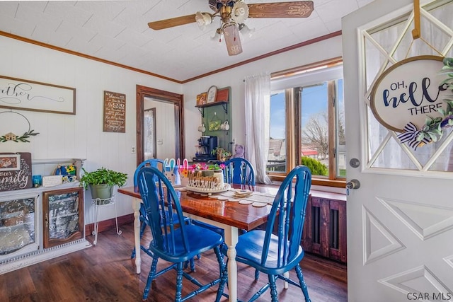 dining room featuring ceiling fan, baseboards, ornamental molding, and wood finished floors