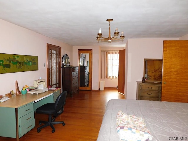 bedroom featuring wood-type flooring, a chandelier, and built in desk