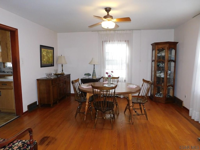 dining space with ceiling fan and wood-type flooring