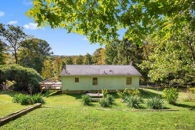 back of house featuring a wooden deck and a lawn