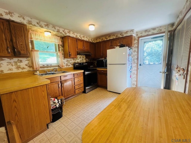 kitchen featuring white fridge, sink, and stainless steel electric range