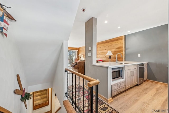 interior space with recessed lighting, stainless steel appliances, a sink, light countertops, and light wood finished floors