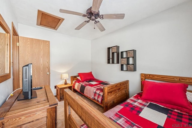 bedroom featuring attic access, carpet floors, and a ceiling fan