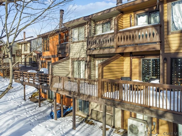 snow covered back of property with ac unit