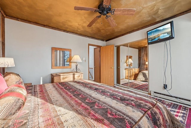 bedroom featuring baseboard heating, a closet, and a ceiling fan