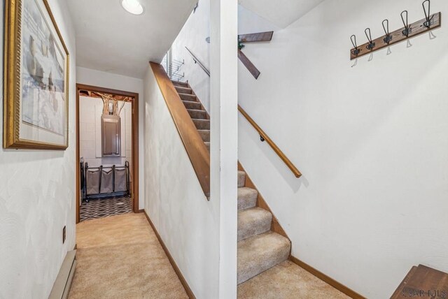 staircase featuring carpet and baseboards