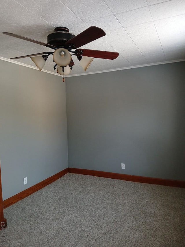 empty room with ornamental molding, carpet floors, and ceiling fan