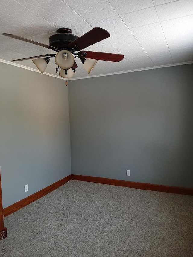 carpeted spare room featuring crown molding and ceiling fan