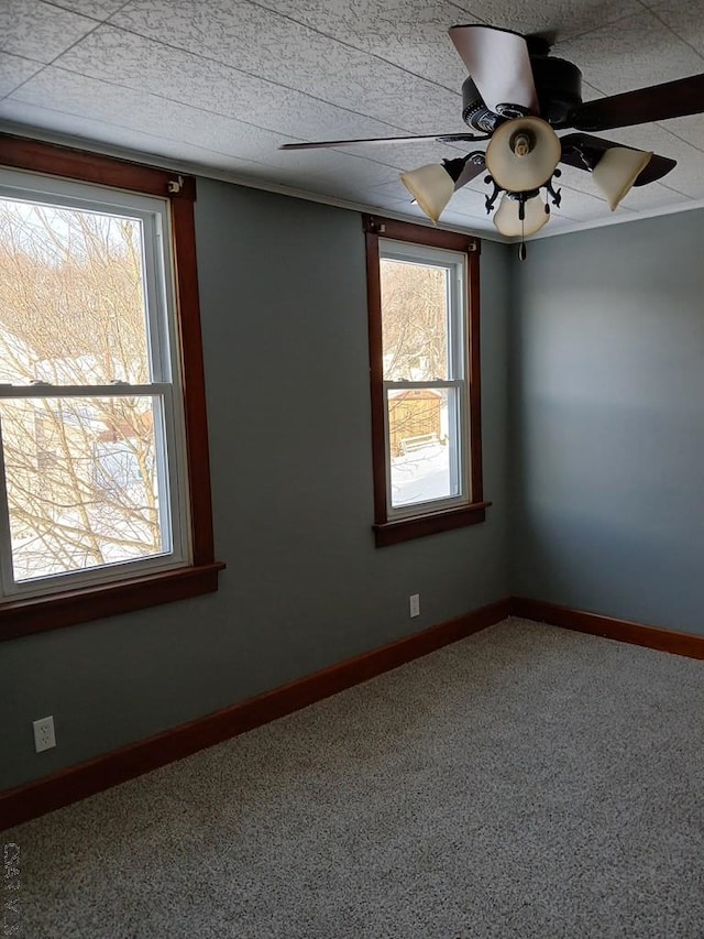 carpeted spare room with a wealth of natural light and ceiling fan