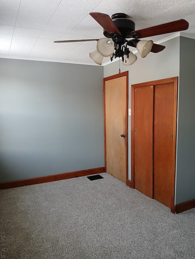 unfurnished bedroom with carpet flooring, ceiling fan, and a closet