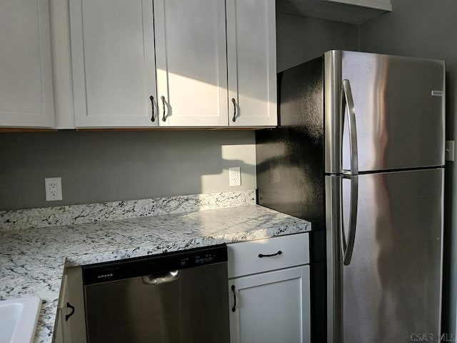 kitchen featuring white cabinetry, light stone countertops, and stainless steel appliances