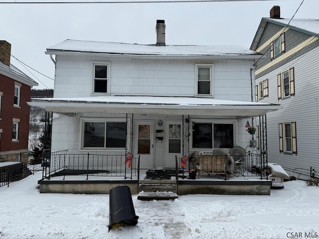 view of front facade with a porch and a chimney