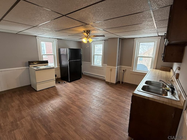 kitchen with a baseboard heating unit, white range with electric cooktop, plenty of natural light, and freestanding refrigerator