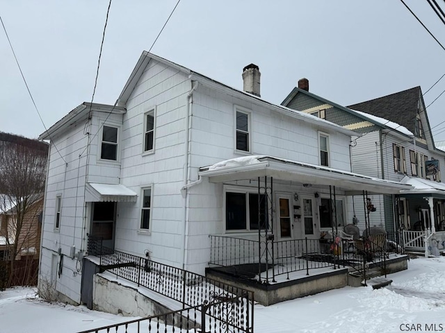 view of front of home with a porch and a chimney