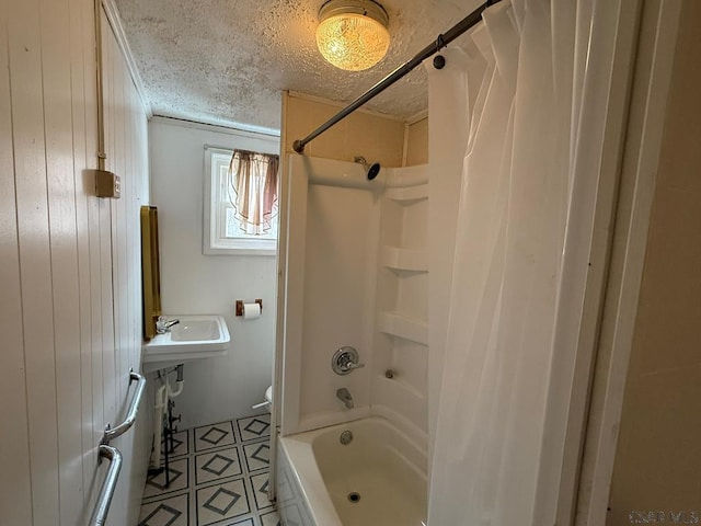 full bath featuring  shower combination, wood walls, a textured ceiling, and toilet