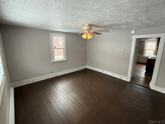 unfurnished room with a ceiling fan, dark wood finished floors, a textured ceiling, and baseboards