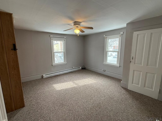 unfurnished bedroom featuring a baseboard heating unit, carpet flooring, a ceiling fan, and baseboards