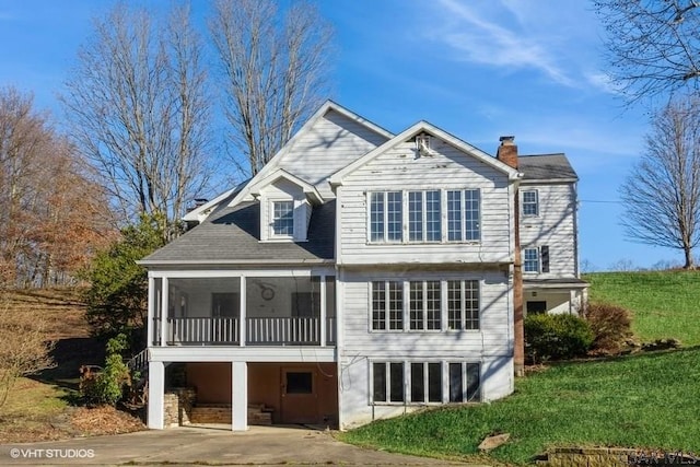 rear view of property with a yard and a sunroom