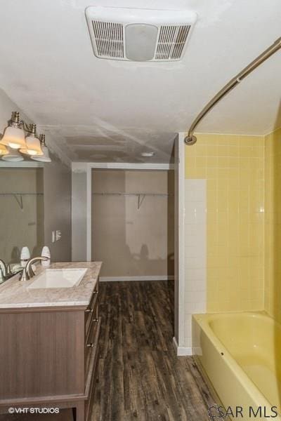 bathroom featuring hardwood / wood-style flooring, vanity, and shower / washtub combination