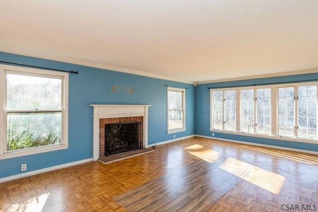 unfurnished living room featuring a brick fireplace, crown molding, and parquet floors