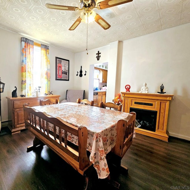 dining area with an ornate ceiling, a fireplace, baseboards, and dark wood finished floors