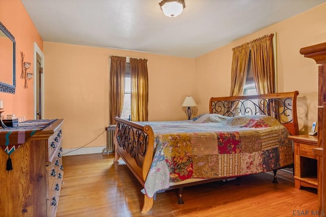 bedroom featuring radiator and wood finished floors