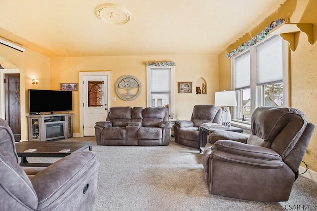 carpeted living room featuring arched walkways