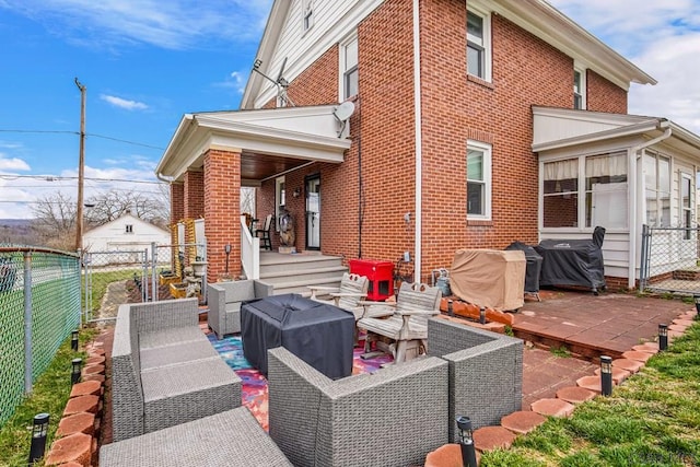 back of property featuring an outdoor hangout area, a gate, fence, and a patio area
