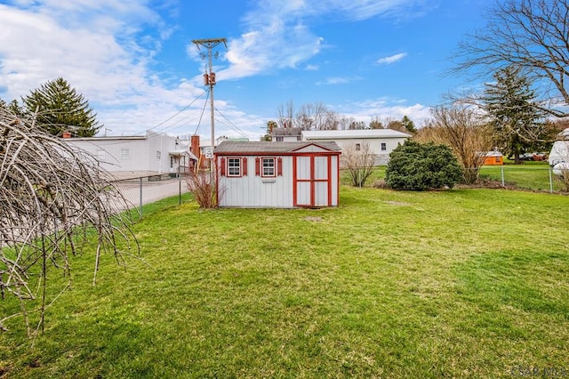 view of yard with an outdoor structure, a fenced backyard, and a storage shed