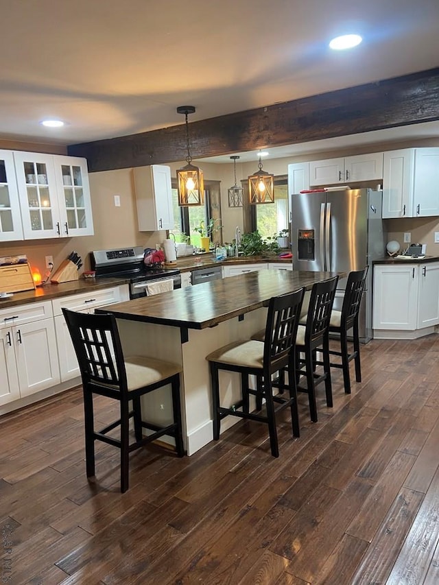 909 Snake Rd, Ebensburg, PA 15931 - kitchen with appliances with stainless steel finishes, wooden counters, dark wood-type flooring, a kitchen bar, and glass insert cabinets