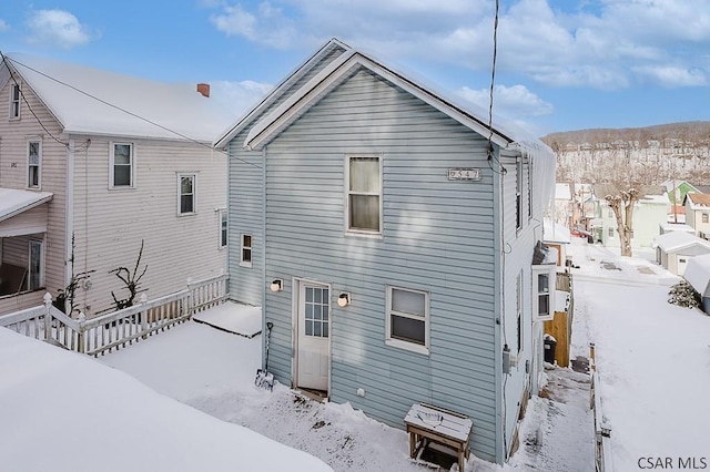 view of snow covered back of property