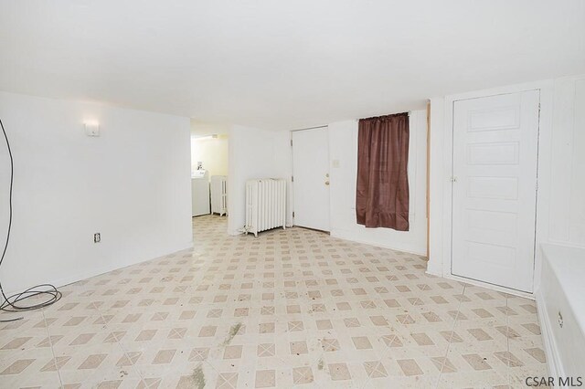 unfurnished room with radiator and independent washer and dryer