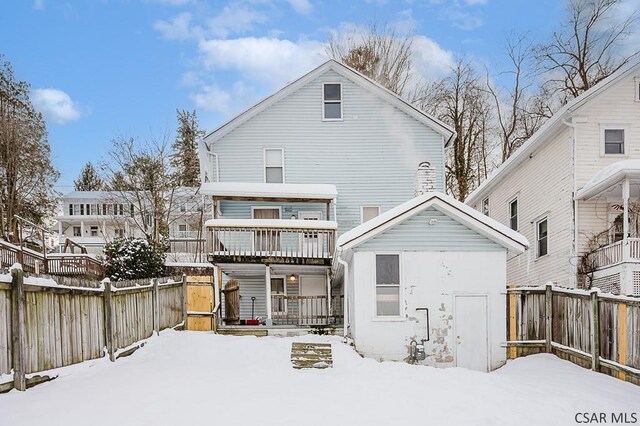 view of snow covered rear of property