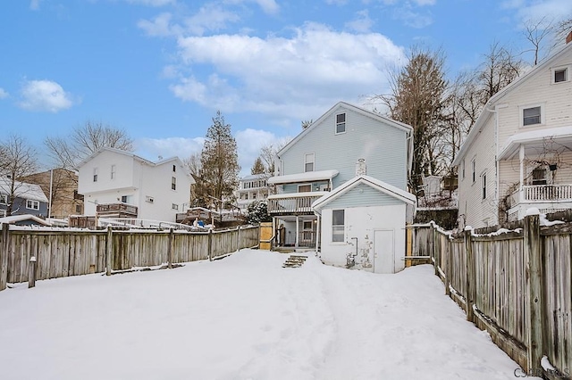 view of snow covered rear of property