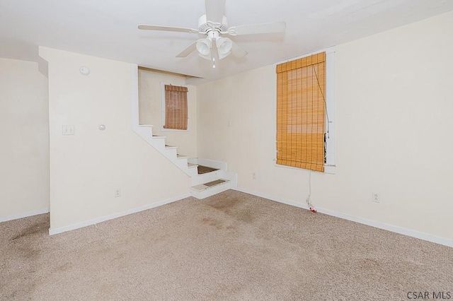 carpeted spare room featuring ceiling fan