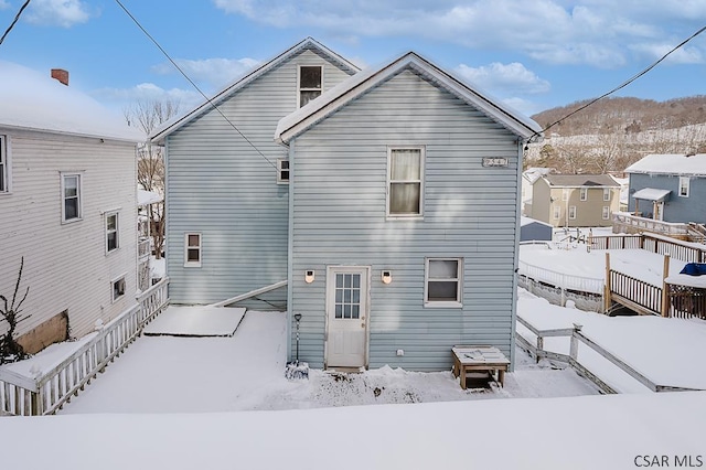 view of snow covered back of property